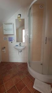 a bathroom with a shower and a sink at Dom Wypoczynkowy IRMINA in Karwia