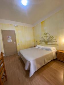 1 dormitorio con 1 cama blanca grande en una habitación en Green Gallery Hotel and Restaurant en Muravera