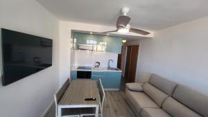 a living room with a couch and a table and a kitchen at Luna Almerimar Golf in Almerimar