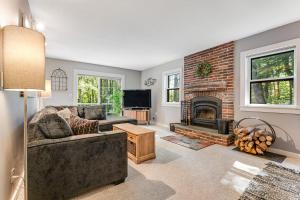 a living room with a couch and a fireplace at Bayley Way Getaway in White River Junction