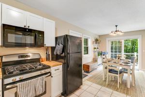 a kitchen with a stainless steel refrigerator and a table at Bayley Way Getaway in White River Junction