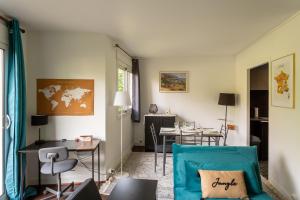 a living room with a blue couch and a table at T3 4P à 5 min Gare RER Univ Paris Saclay et 30 min de Paris Centre in Orsay
