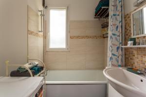 a bathroom with a bath tub and a sink at T3 4P à 5 min Gare RER Univ Paris Saclay et 30 min de Paris Centre in Orsay +16 photos
