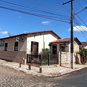 uma pequena casa branca ao lado de uma rua em Pousada Recanto da Vila em Pirenópolis