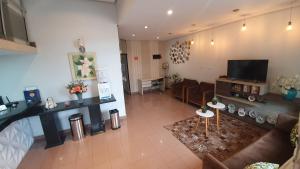 a living room with a couch and a tv at Hotel Magnólia in São João da Boa Vista