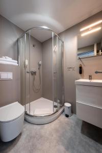 a bathroom with a shower with a toilet and a sink at Berlin Studios in Klaipėda