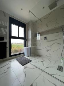 baño blanco con ducha y ventana en Bel Appartement de standing, en Ouled Moussa
