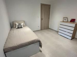 Ouled Moussa的住宿－Bel Appartement de standing，一间卧室配有一张大床和一个梳妆台