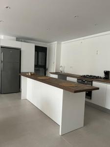 Bel Appartement de standing في Ouled Moussa: مطبخ بدولاب بيضاء وقمة كونتر خشبي