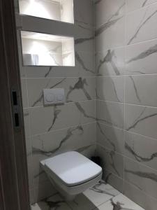 ein weißes Bad mit einem WC und einem Fenster in der Unterkunft Bel Appartement de standing in Ouled Moussa