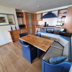 a kitchen with a wooden table and blue chairs at All Exclusive Apartments in Dordrecht
