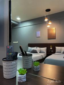 Relaxed Studio Q&S-Bed Near Airport WI-FI-Aeropod Sovo في كوتا كينابالو: غرفة فندقية بسريرين وطاولة