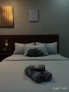 a bed with two towels laying on it at Relaxed Studio Q&S-Bed Near Airport WI-FI-Aeropod Sovo in Kota Kinabalu