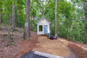 une petite maison dans les bois avec des arbres dans l'établissement 16 Bluebird Feather Tiny Cottage, à Scottsboro