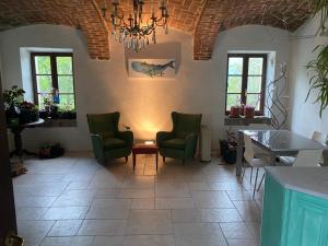 - un salon avec des chaises, une table et un lustre dans l'établissement La Dimora delle Viole, à Lauriano