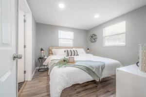 a white bedroom with a large bed and two windows at Newly Renovated Couple’s Retreat 2Bd/1B with King Bed in Tampa