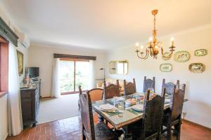 une salle à manger avec une table et un lustre dans l'établissement Cosy Countryside - Family House, à Castelo de Paiva