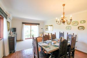 ein Esszimmer mit einem Tisch und einem Kronleuchter in der Unterkunft Cosy Countryside - Family House in Castelo de Paiva