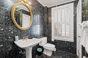 a bathroom with a sink and a toilet and a mirror at The W House Traveler's Dream Heart of Old Town in Alexandria