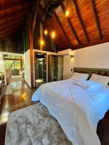 a bedroom with a large bed with a wooden ceiling at Recanto das Cachoeiras in Angelina