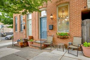 a brick house with chairs and a blue door at Downtown Baltimore Vacation Rental WFH Friendly! in Baltimore