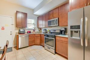 a kitchen with wooden cabinets and stainless steel appliances at Downtown Baltimore Vacation Rental WFH Friendly! in Baltimore