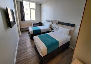 ein Hotelzimmer mit 2 Betten und einem Fenster in der Unterkunft Hotel Diego de Almagro Calama Express in Calama