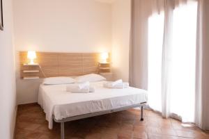 1 dormitorio con 1 cama con sábanas y almohadas blancas en Villa Blumarine sul mare en San Vito lo Capo