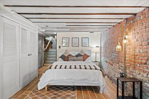 a bedroom with a bed and a brick wall at The W House Traveler's Dream Heart of Old Town in Alexandria
