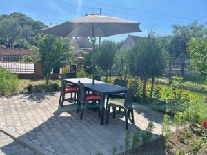 un tavolo e sedie con ombrellone su un patio di Noclegi Budomas Klima-ParkigFree-SmartTv a Breslavia
