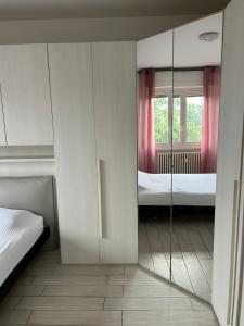 een kamer met een spiegel en een slaapkamer met 2 bedden bij Parkside Heaven Milano Affori in Milaan