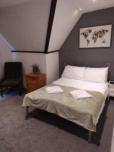 a bedroom with a bed with two towels on it at Rock House Bed and Breakfast in Maidstone