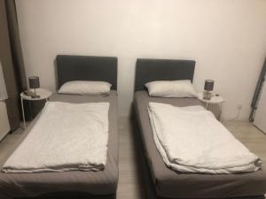 2 letti in una camera con lenzuola e cuscini bianchi di Wohnung in Köln 2B a Colonia