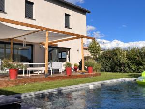 a house with a swimming pool in front of a house at Magnifique Villa, Piscine, Proche Plage, 8 personnes in Lansargues