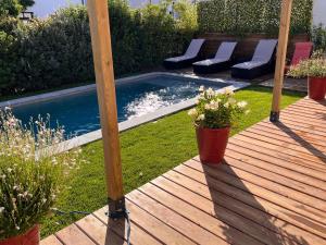 a wooden deck with a swimming pool in a yard at Magnifique Villa, Piscine, Proche Plage, 8 personnes in Lansargues