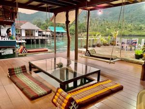a patio with a glass table and benches on a deck at Good View by Koi, Koh Chang in Ko Chang