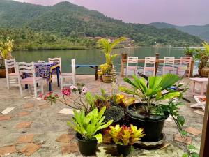 a patio with chairs and plants and a view of a lake at Good View by Koi, Koh Chang in Ko Chang
