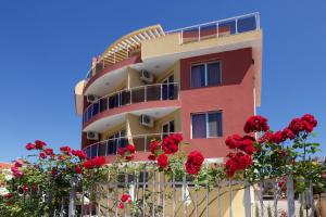 サニービーチにあるSunny Flower Family Hotelの赤いバラが目の前に見える建物