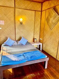 a bed in a tent with a light on the wall at Good View by Koi, Koh Chang in Ko Chang