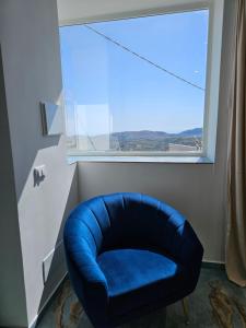 einen blauen Stuhl in einem Zimmer mit Fenster in der Unterkunft Antico Borgo dei Templi in Agrigento