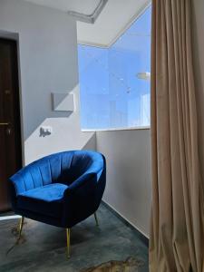 a blue chair in a room with a window at Antico Borgo dei Templi in Agrigento