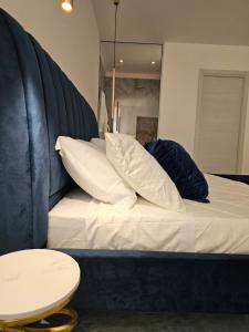 ein Bett mit weißer Bettwäsche und Kissen sowie einem Tisch in der Unterkunft Antico Borgo dei Templi in Agrigento