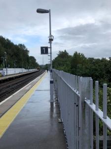 una plataforma de tren con una valla blanca y un semáforo en House o' Books en Londres