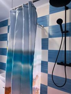 a shower curtain in a bathroom with a tile wall at Casa Rarăului in Câmpulung Moldovenesc