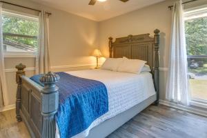 a bedroom with a bed with a blue blanket and two windows at Pet-Friendly Rex Vacation Rental 18 Mi to Atlanta in Rex