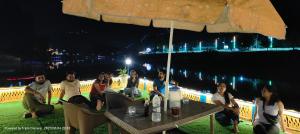 a group of people sitting at a table at night at Houseboat Karima palace in Srinagar