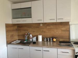 a kitchen with white cabinets and a sink at Apartman Perper 2 Trebinje in Trebinje
