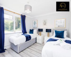 Duas camas num quarto com cortinas azuis em Large 2 Bed Apartment by AV Stays East Croydon em South Norwood