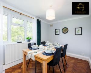 een eetkamer met een houten tafel en stoelen bij Large 2 Bed Apartment by AV Stays East Croydon in South Norwood