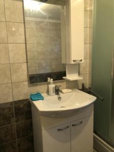 a bathroom with a white sink and a mirror at Apartman Perper 2 Trebinje in Trebinje